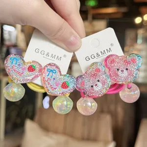 Primo piano dettagliato di elastici per capelli glitterati con cuori e simpatici orsi.