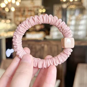 Suave coletero de pelo rosa plisado con detalle de cuenta cuadrada para peinados elegantes.