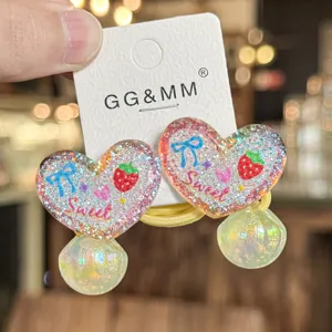 Dettaglio elastico capelli cuore glitterato, accessorio bimba fiocco fragola con cartellino.