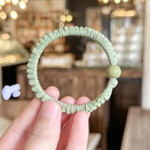 Green pleated hair scrunchie with round bead, soft elastic hair tie for women and girls daily use.