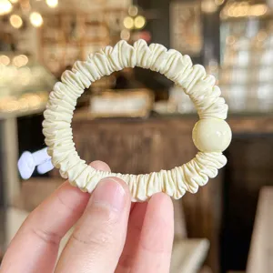 Soft pleated hair scrunchie with bead detail, simple elastic hair tie for women and girls daily wear.