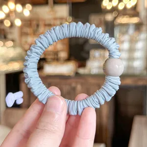 Soft pleated hair scrunchie with round bead detail, elegant elastic hair tie accessory.