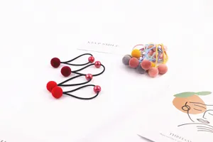 Λεπτομερής όψη από χρωματιστά βελούδινα λαστιχάκια μαλλιών με χαριτωμένες μπάλες.