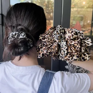 Detailed view of large leopard print hair scrunchie, stylish fabric hair accessory for women.