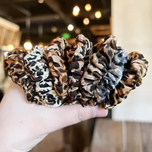 Set of stylish leopard print and patterned fabric scrunchies for women hair styling accessories.