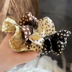 Primer plano detallado de coleteros de tela con estampado de corazones y borde con volantes.