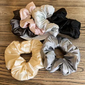 Close-up of smooth satin hair scrunchies in multiple colors, soft and fluffy ponytail holder.