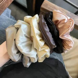 Satin padded scrunchies detail view, showing multiple soft hair ties in various elegant colors.