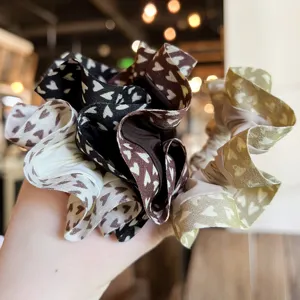 Detalle de coleteros de tela con estampado de corazones, gomas de pelo suaves para mujeres.