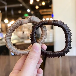 Detail view of stylish satin scrunchies in brown tones, high elasticity hair ties.