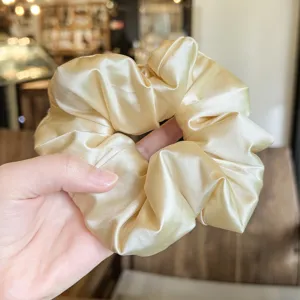 Satin scrunchie detail close-up, soft fluffy champagne hair tie for women styling.
