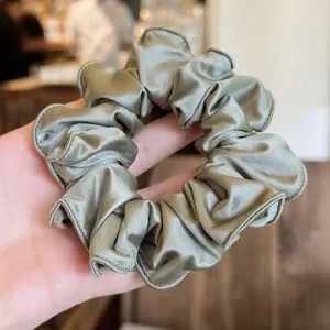 Minimalistische satijnen haarelastiek voor dames, elegante groene paardenstaart haaraccessoire.