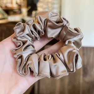 Detail van elegante satijnen haarscrunchie, zachte paardenstaarthouder voor chique dagelijkse look.