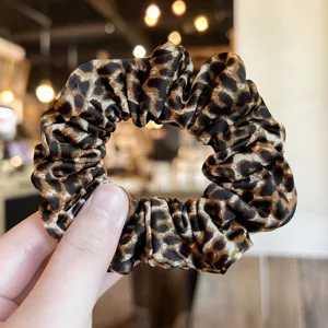 Leopard print hair scrunchie detail shot, elegant fabric hair band for women and girls daily styling.