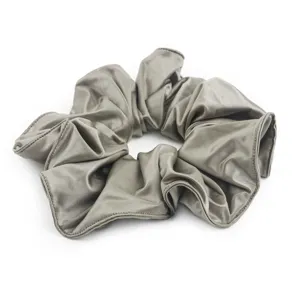 Grijze satijnen haarscrunchie detailfoto, elegant zacht haaraccessoire voor stijlvolle paardenstaarten.
