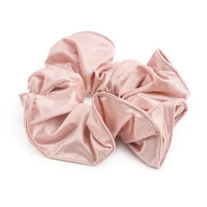Detailopname van een roze satijnen haarelastiek, glanzende stoftextuur voor elegante kapsels.