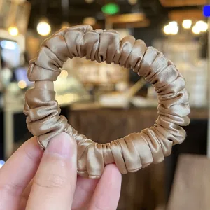 Satin scrunchie detail shot, elegant brown hair tie for women, smooth texture ponytail holder.
