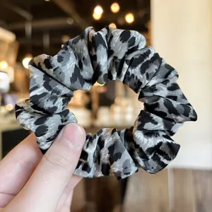 Black and grey leopard print hair scrunchie detail view, elegant fabric hair tie for women.