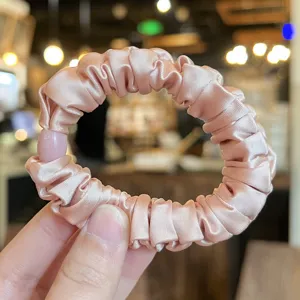 Elegant pink satin hair scrunchie featuring high elasticity, ideal for stylish daily ponytail wear.