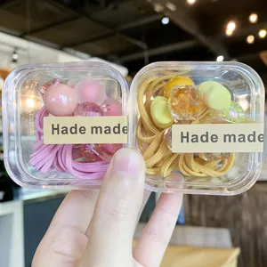 Jolis élastiques à cheveux colorés en boîte avec récipient transparent, accessoire idéal.
