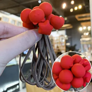 Détail chouchous enfants mignons, perles dessin animé silicone rouge et élastiques marron.