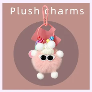 Gros plan détaillé d'un charm porte-clés en peluche rose avec des lunettes de soleil.