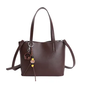 Brown leather tote bag for women, stylish commuting crossbody handbag with charm.