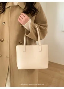 Minimalist beige tote bag for women, stylish commuting handbag with comfortable double handles.