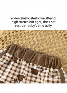 Detailed close-up of kids summer casual plaid shorts elastic waistband soft fabric print design.