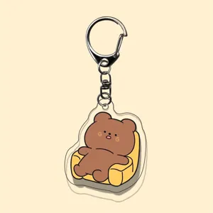 Close-up of clear acrylic cute cartoon bear keychain pendant, detailed view, stylish accessory.