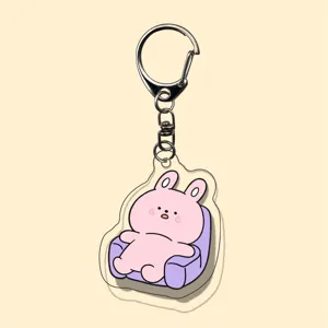 Acrylic cartoon keychain detail, cute pink animal on sofa, transparent double-sided pendant.