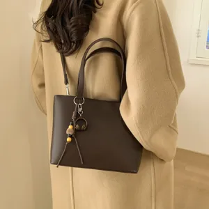 Chic women commuter tote bag, stylish autumn winter shoulder bag with trendy charm pendant.