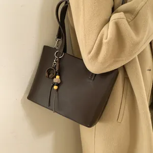 Stylish brown leather tote bag for women, autumn winter casual shoulder handbag with charm.