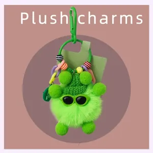 Vue détaillée de la breloque en peluche verte avec lunettes de soleil et perles colorées.