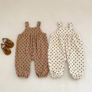 Dettaglio salopette neonato in velluto a coste a pois, tessuto morbido e design adorabile per bimbi.
