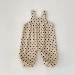 Dettaglio tutina neonato in velluto a coste con pois, simpatico abbigliamento autunnale.
