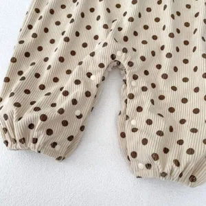 Graziosa tutina neonato in corduroy a pois in dettaglio, tessuto morbido, comoda tuta per infanti.
