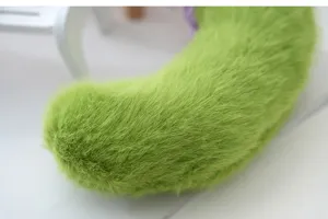 Cute green cucumber plush toy detail shot, soft furry bag charm and fluffy keychain.