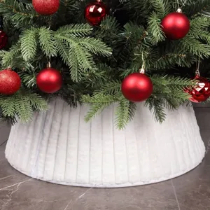 Vue détaillée de la jupe de sapin de Noël en peluche plissée blanche avec des boules.