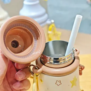 Vue détaillée de la jolie tasse thermos en acier inoxydable avec motif étoile et paille.