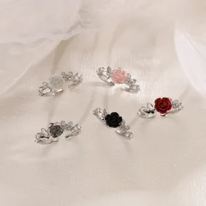 Primo piano dettagliato di eleganti anelli con motivo floreale e farfalla tempestati di zirconi.