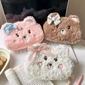 Close-up detail of fluffy bear pencil pouch with cute embroidered face and ribbon bow aesthetic.