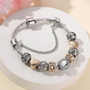 DIY bedelarmband met zilveren slangenketting, gouden hart hanger, strass en kristalen.