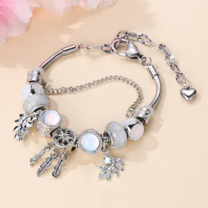 Detailed view of silver charm bracelet with opal beads, dreamcatcher and delicate leaf charms.