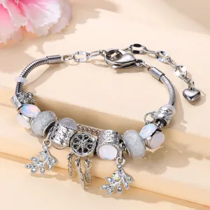 Silver charm bracelet with opal beads, dreamcatcher pendant, and leaf crystal dangles.