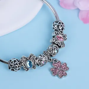 Silbernes Charm Armband Detail mit glitzernden bunten Kristallperlen und Kleeblatt Anhänger.