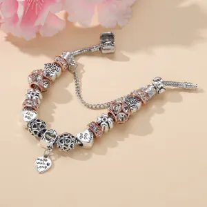 Gros plan détaillé d'un bracelet charms DIY argenté avec des billes de cristal rose or.
