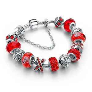 Silbernes Charm-Armband mit roten Kristallperlen, floralen Glasperlen und Sicherheitskette.