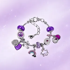 Dettaglio ravvicinato di bracciale charm fai-da-te in argento con perline viola e ciondoli dolci.