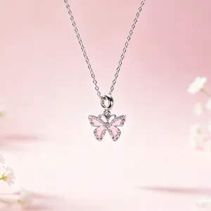 Primo piano della squisita collana con ciondolo a farfalla in argento, smalto rosa e cristalli.